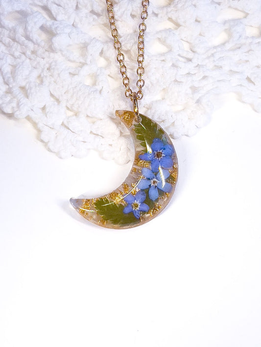 Moon pendant necklace made with real forget-me-not flowers and ferns.