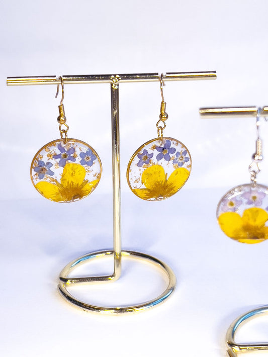 Round dangle earrings made with pressed forget-me-nots and buttercups picked in Nova Scotia.