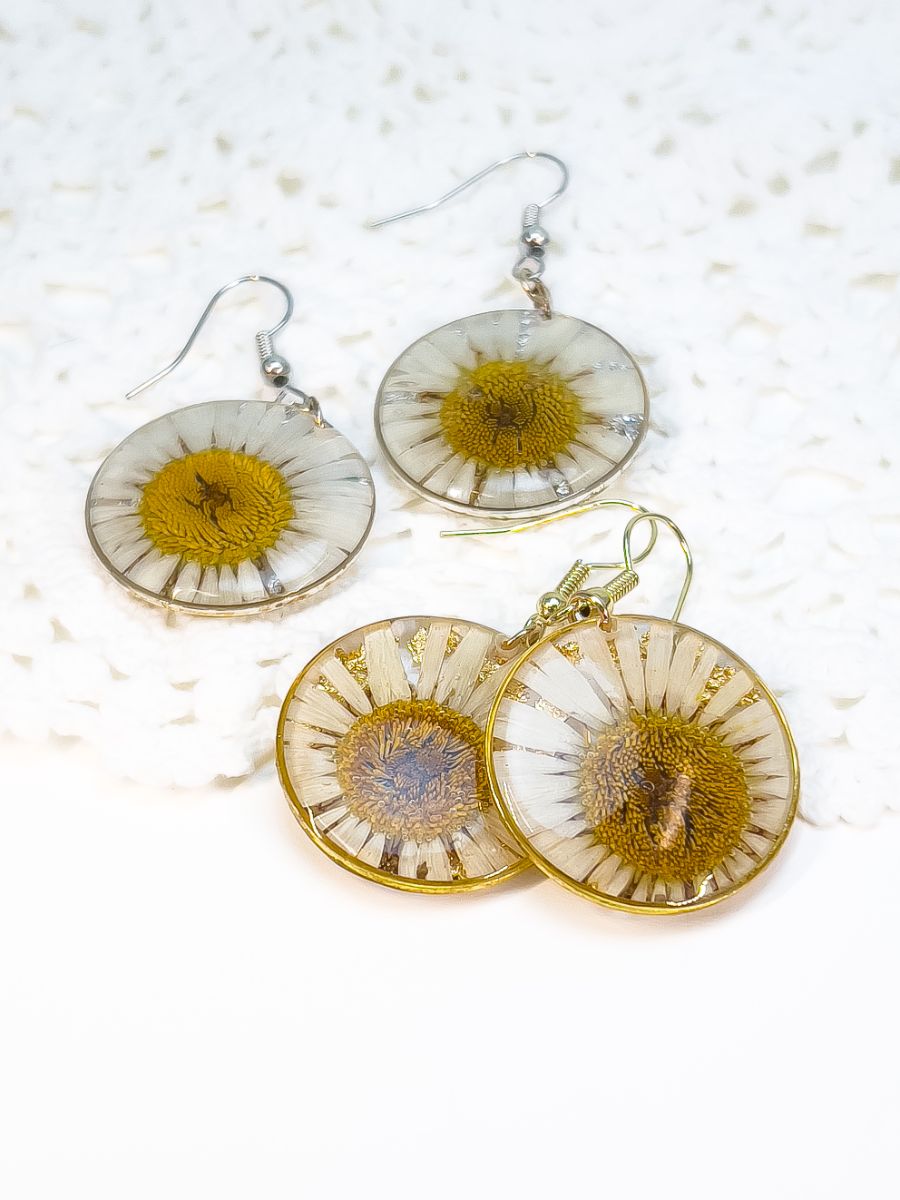 Both gold and silver pairs of pressed daisy earrings. 
