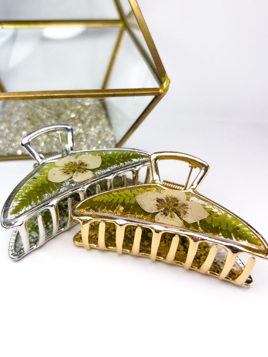 Side view of two metal hair clips made with real pressed dogwood flowers and ferns from Nova Scotia.