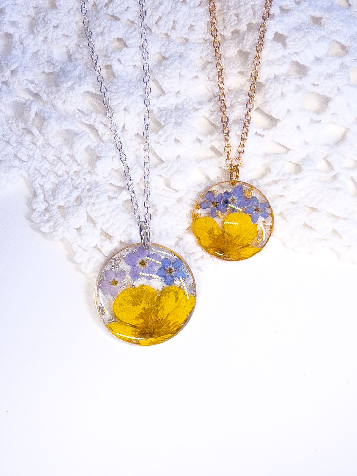 Round pendant necklaces made with pressed forget-me-not and buttercup flowers. 