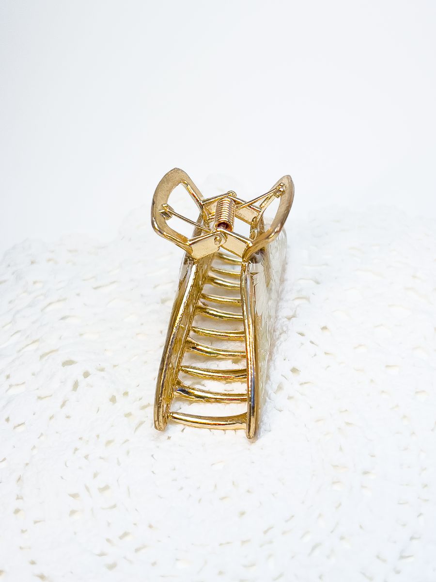 Side view of gold metal flower hair clip.
