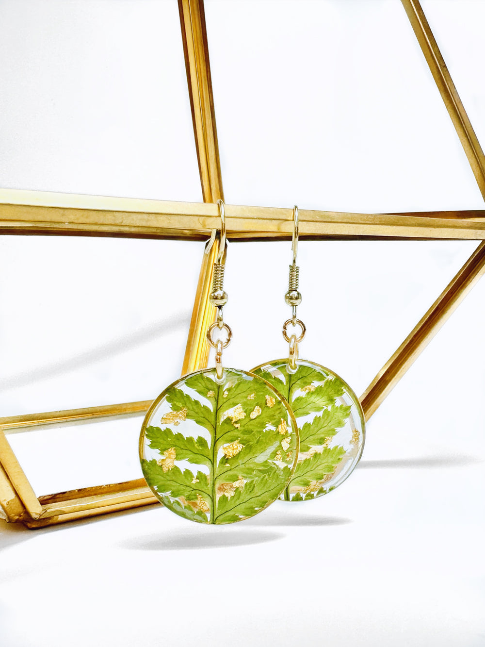 Round pendant dangle earrings made from pressed ferns in Nova Scotia.