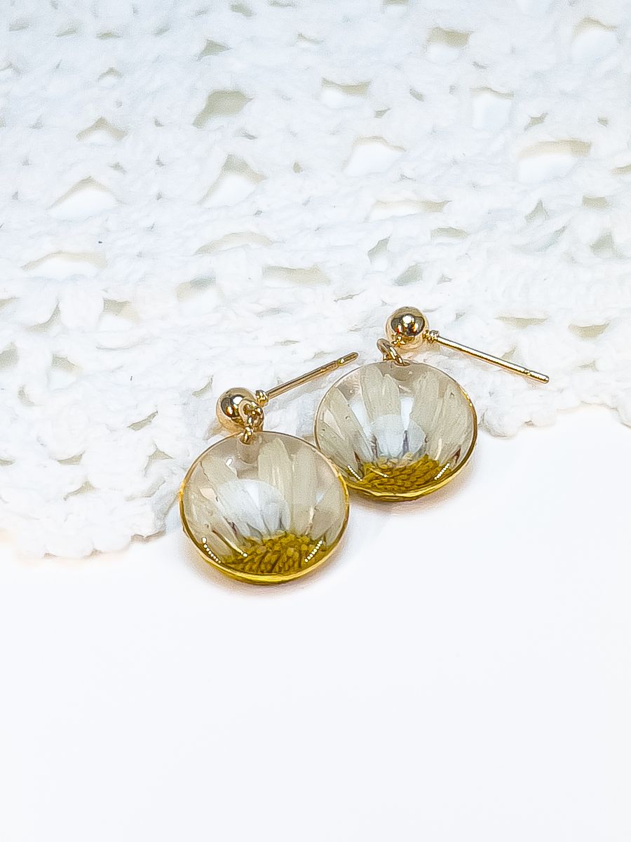 A pair of circle pendant dangle earrings made with real pressed daisies. 